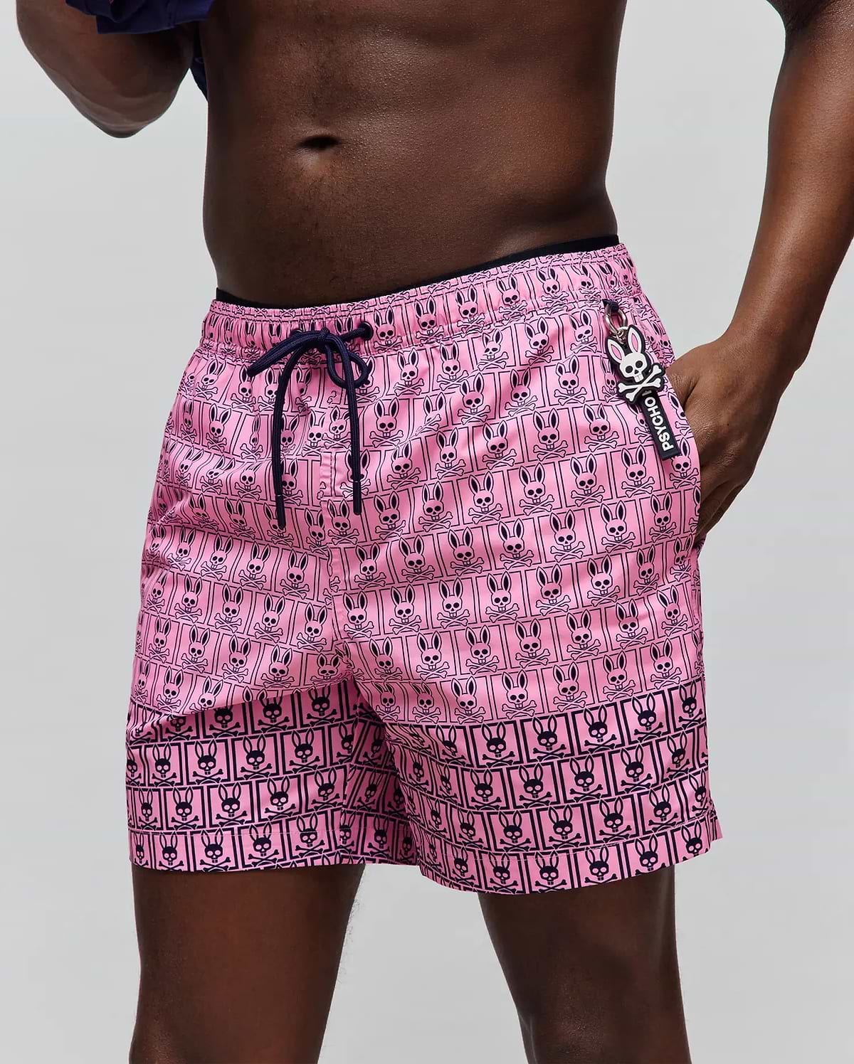 Mens Keon Swim Trunk, vibrant pink with a classic fit and smooth quick-dry fabric. Features an all-over navy grid print of Psycho Bunny heads and skull & crossbones, navy drawstring, and a small side logo tag. (2)