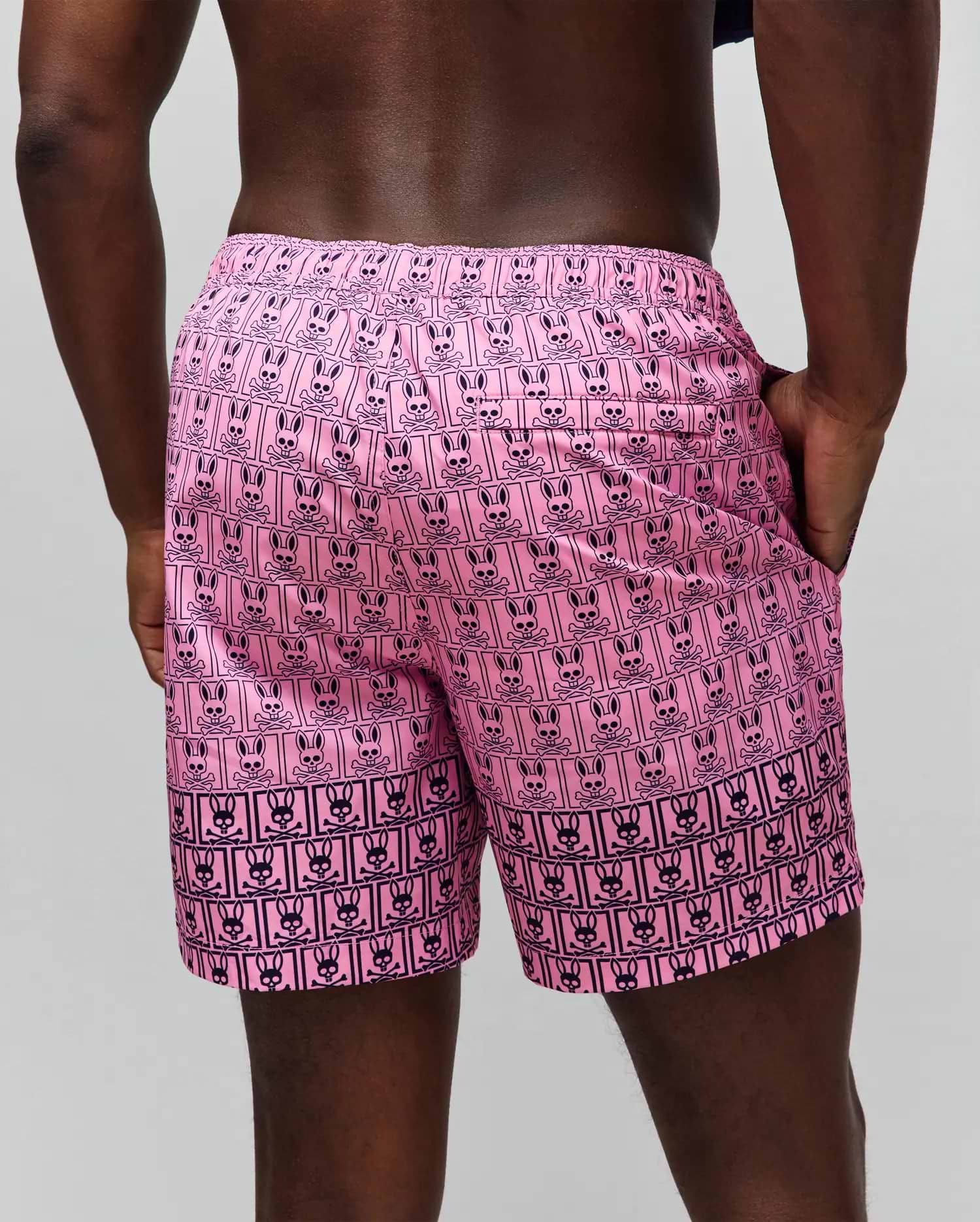 Mens Keon Swim Trunk in vibrant pink with an all-over black Psycho Bunny skull and crossbones logo print, featuring an elastic waistband and side pockets, in a relaxed fit. (3)
