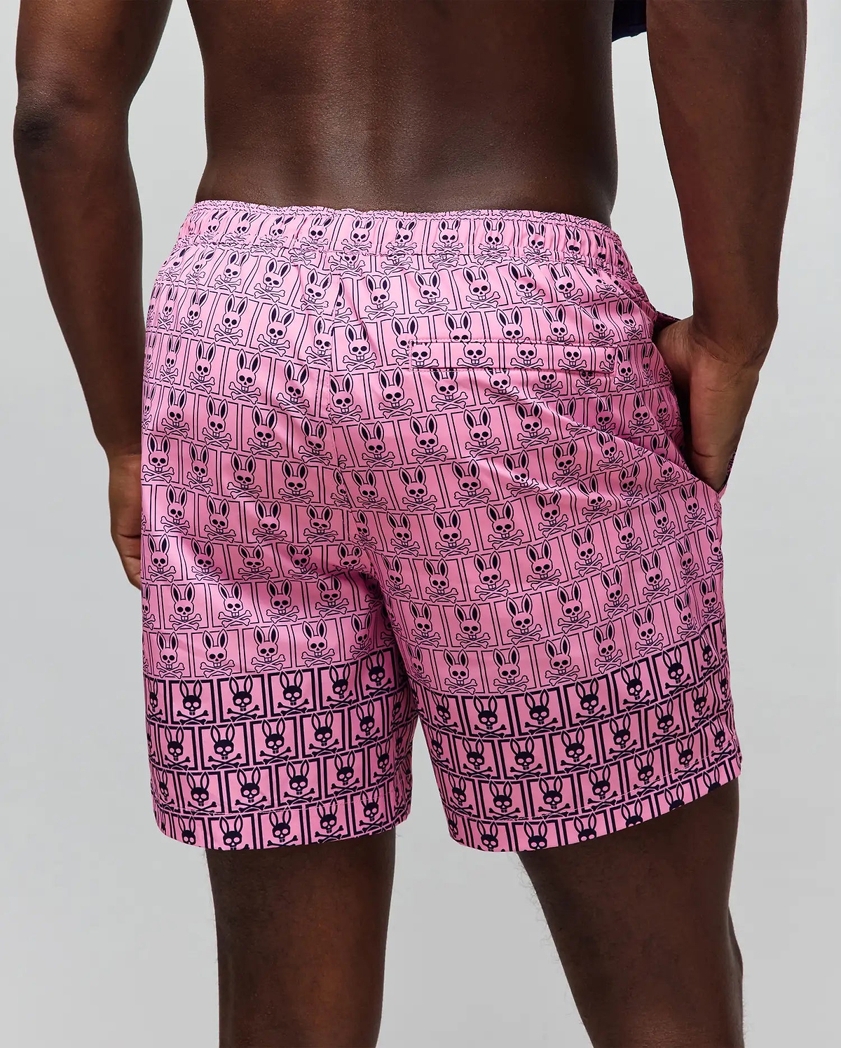 Mens Keon Swim Trunk in vibrant pink with an all-over black Psycho Bunny skull and crossbones logo print, featuring an elastic waistband and side pockets, in a relaxed fit. (3)
