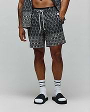 Mens Keon All Over Bunny Swim Trunk, black with a white all-over repeating bunny skull logo pattern, featuring a white drawstring and a black elastic waistband with white Psycho Bunny text, in a relaxed fit.