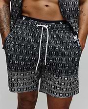 Mens Keon All Over Bunny Swim Trunk, black with a white repeating bunny skull pattern, white drawstring, branded waistband, and a small rubberized Psycho Bunny tag with a pink bunny skull.