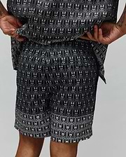 Mens Keon All Over Bunny Swim Trunk, black with an iconic white Psycho Bunny skull logo pattern repeated in rectangular frames, featuring a relaxed fit and smooth, quick-dry fabric.