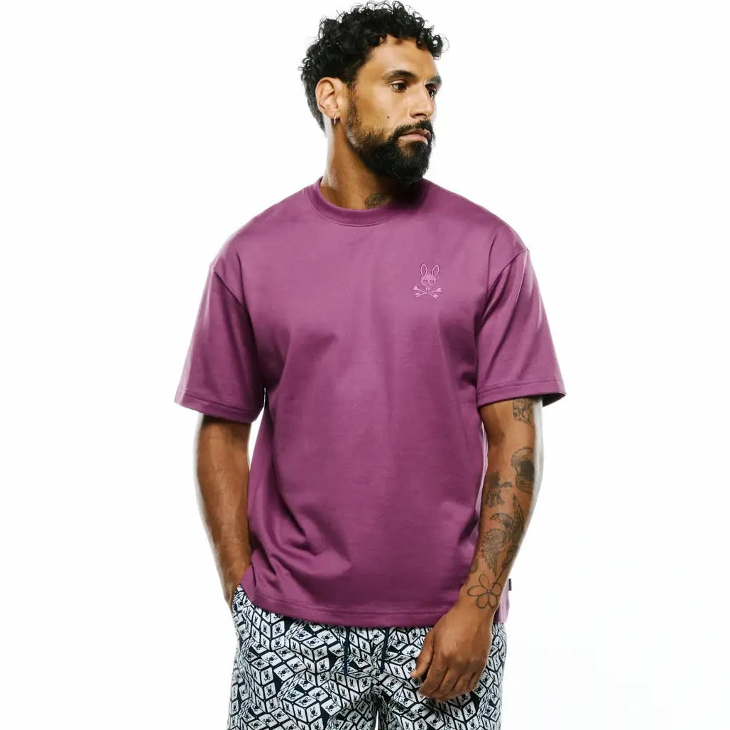 Relaxed fit plum jersey t-shirt with small tonal embroidered Psycho Bunny logo on left chest, paired with Mens Eddy All Over Print Swim Trunk featuring a black and white geometric pattern with integrated Psycho Bunny logos. (4)