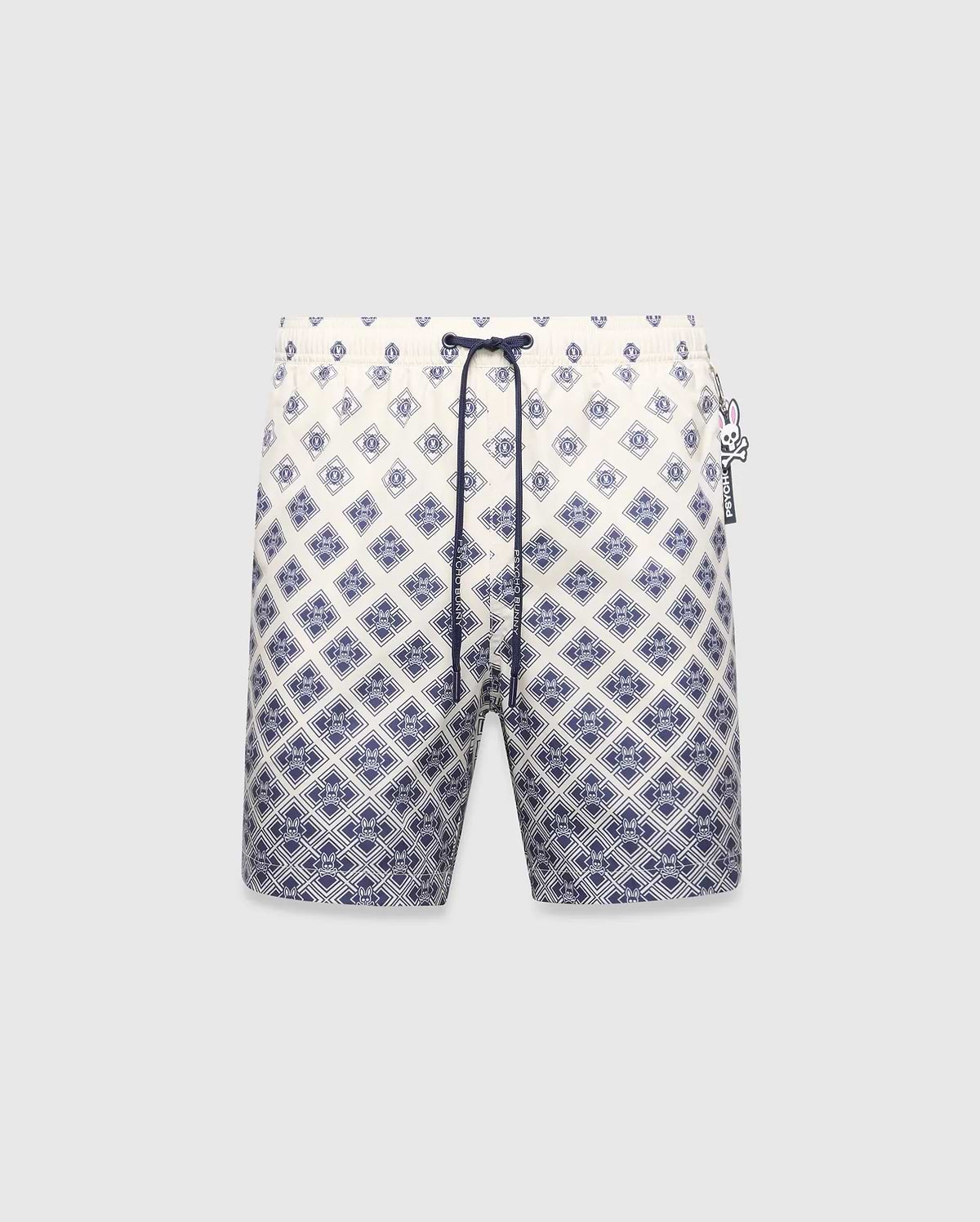 Mens Tobias Swim Trunk, cream with a navy blue gradient geometric pattern subtly integrating the Psycho Bunny skull logo, featuring a navy drawstring and logo zipper pull.