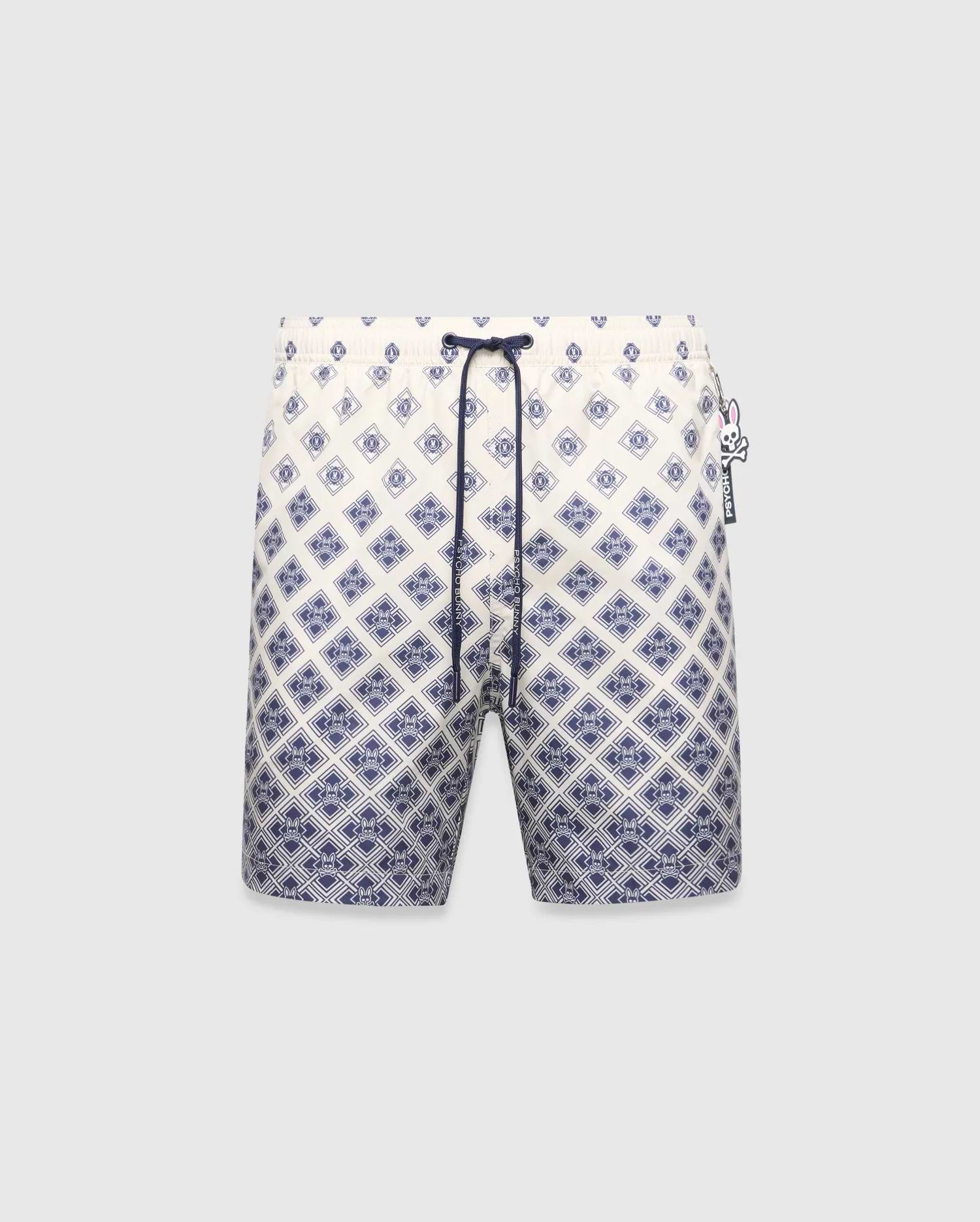 Mens Tobias Swim Trunk, cream with a navy blue gradient geometric pattern subtly integrating the Psycho Bunny skull logo, featuring a navy drawstring and logo zipper pull.