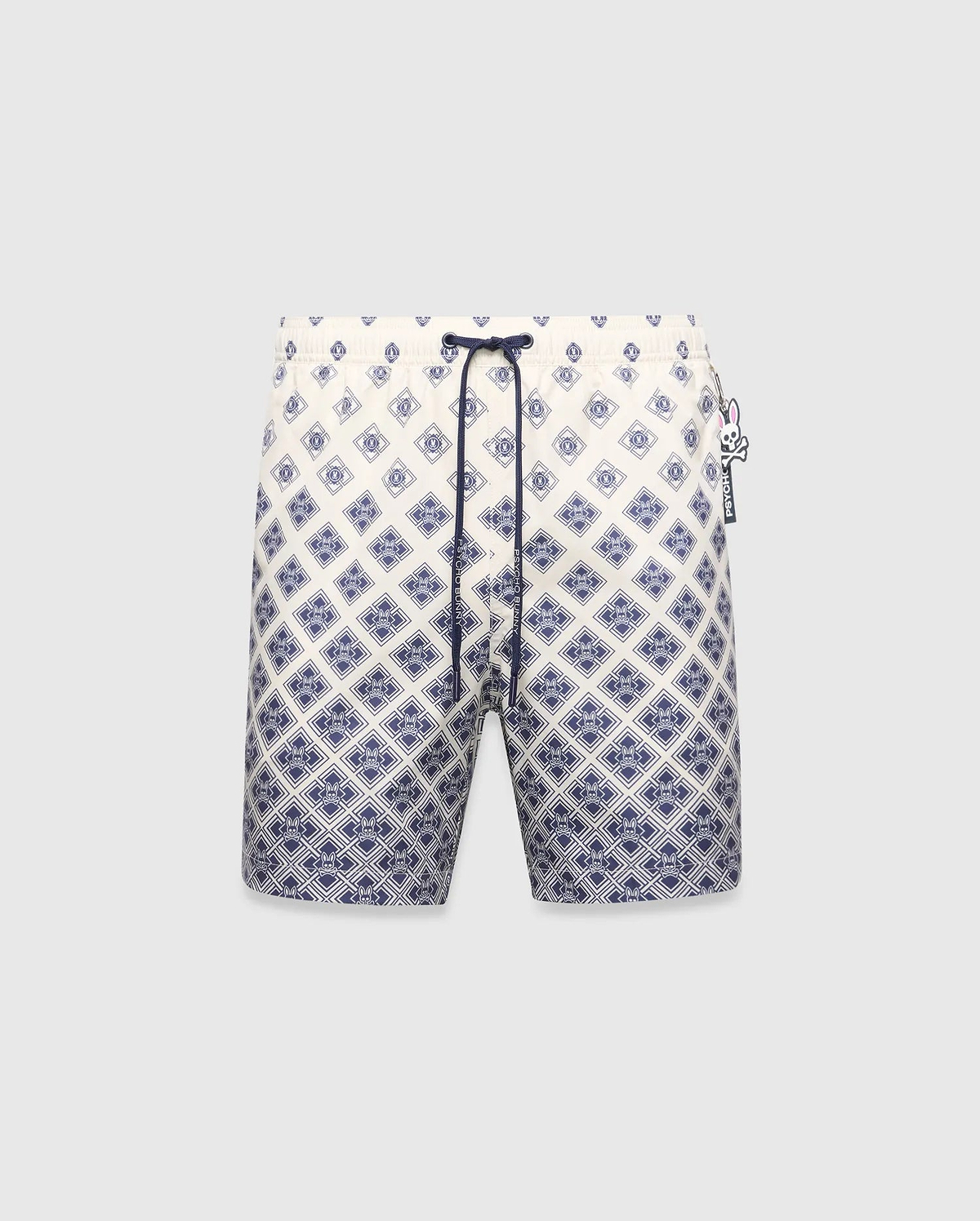 Mens Tobias Swim Trunk, cream with a navy blue gradient geometric pattern subtly integrating the Psycho Bunny skull logo, featuring a navy drawstring and logo zipper pull.