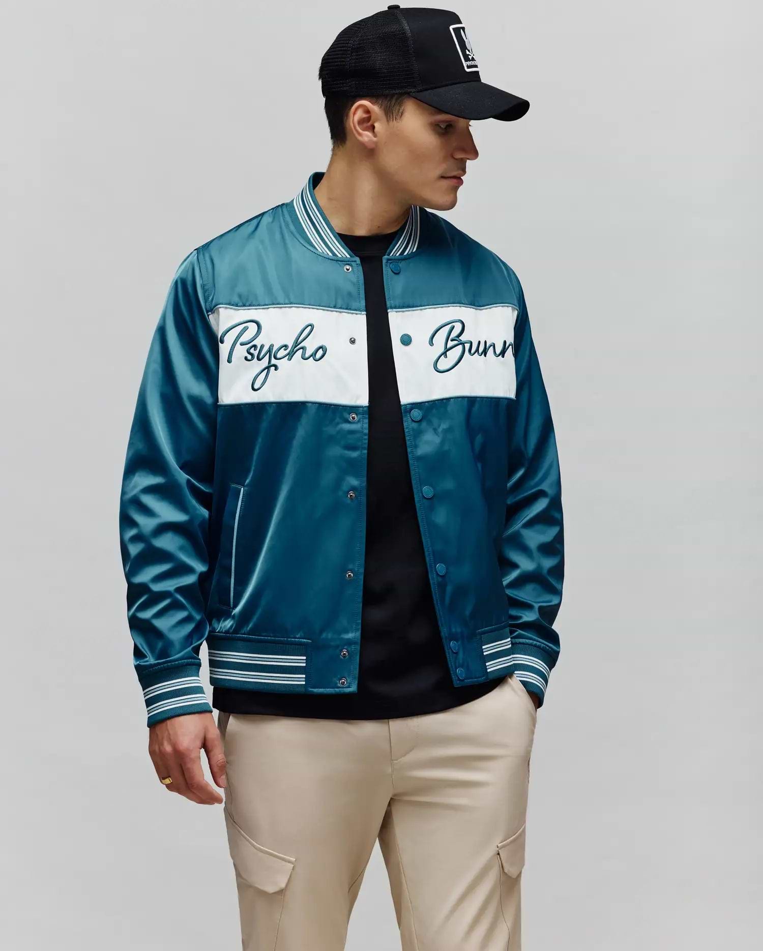 Mens Thomas Satin Bomber in vibrant teal, featuring a prominent white chest stripe with an embroidered Psycho Bunny script logo, and classic striped ribbed collar, cuffs, and hem.
