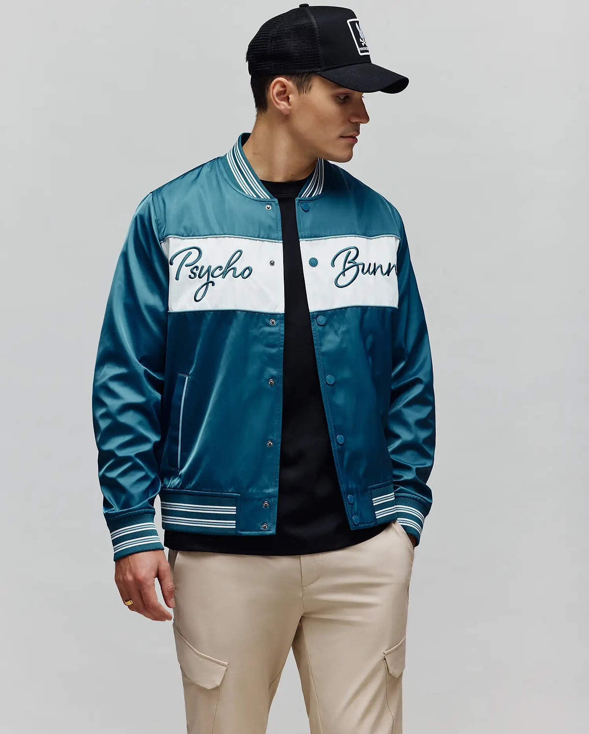Mens Thomas Satin Bomber in vibrant teal, featuring a prominent white chest stripe with an embroidered Psycho Bunny script logo, and classic striped ribbed collar, cuffs, and hem.