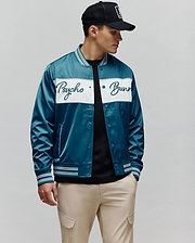 Mens Thomas Satin Bomber in vibrant teal, featuring a prominent white chest stripe with an embroidered Psycho Bunny script logo, and classic striped ribbed collar, cuffs, and hem.