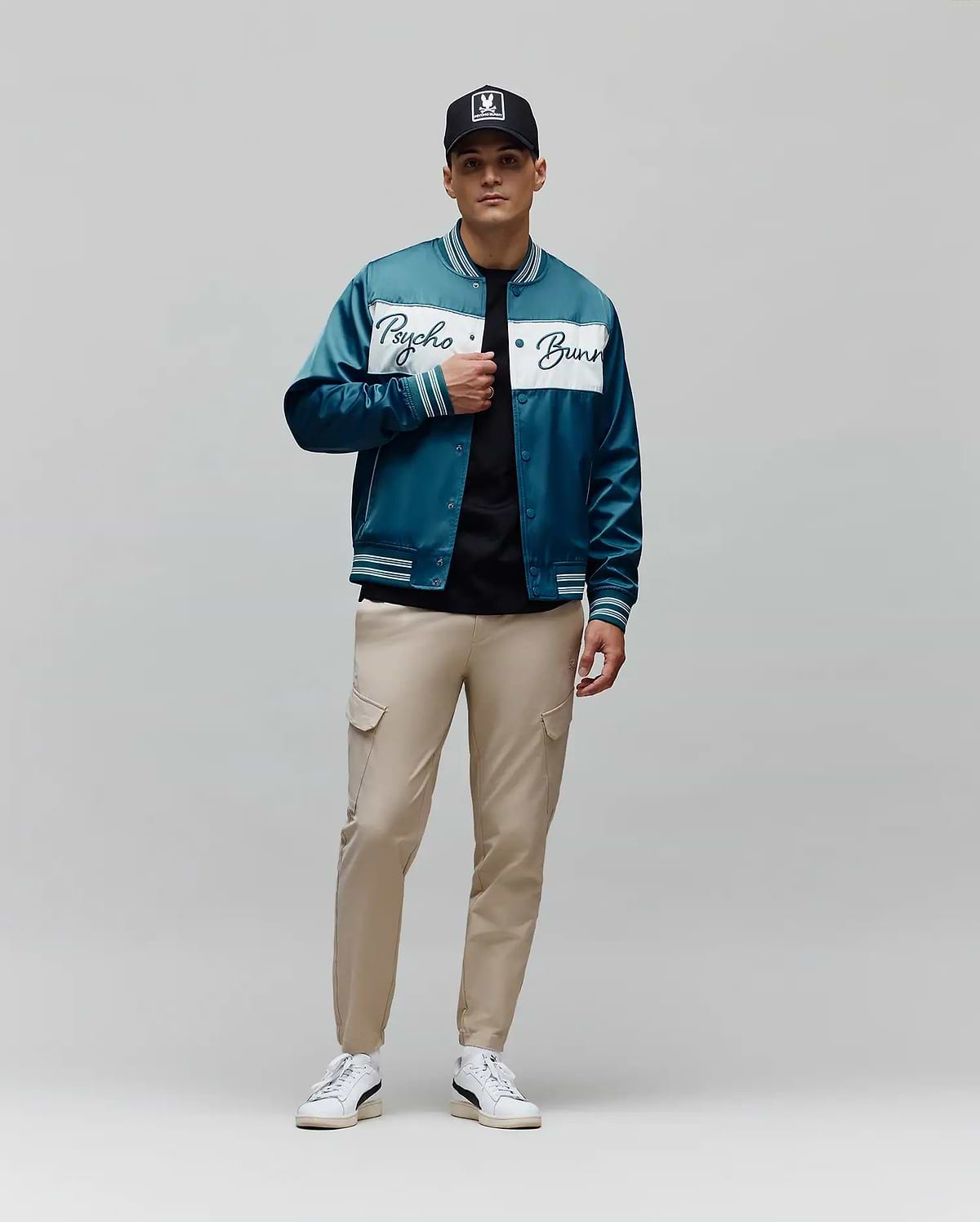 Mens Thomas Satin Bomber in teal, featuring a glossy satin texture, a prominent white chest stripe with a large Psycho Bunny script logo, and striped ribbed cuffs, collar, and hem for a classic fit.
