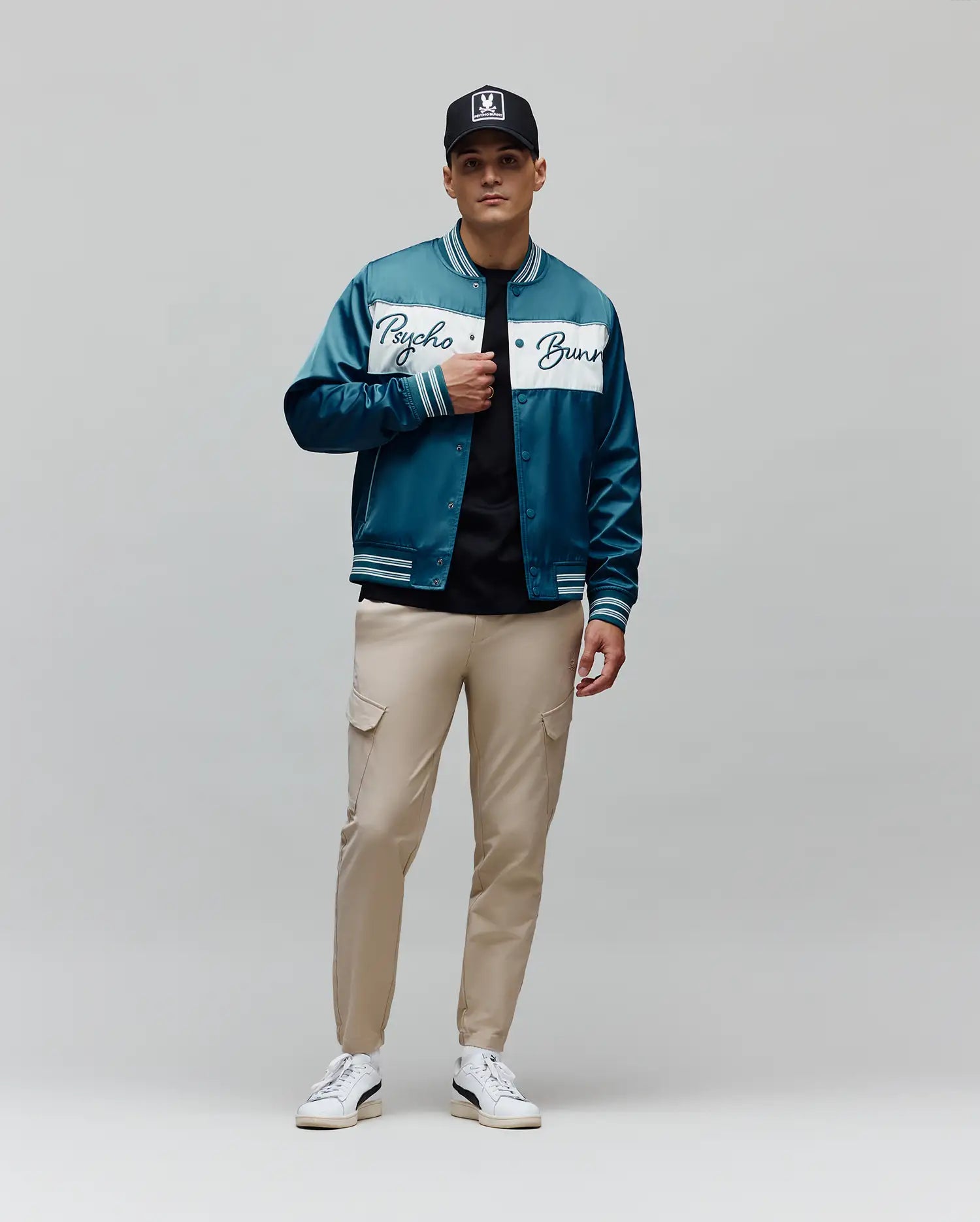 Mens Thomas Satin Bomber in teal, featuring a glossy satin texture, a prominent white chest stripe with a large Psycho Bunny script logo, and striped ribbed cuffs, collar, and hem for a classic fit.