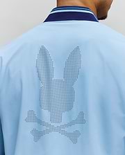 Mens Aldrin Bomber in sky blue, featuring a large perforated Psycho Bunny skull logo centered on the back. It has a smooth fabric and a navy and light blue striped ribbed collar. (4)