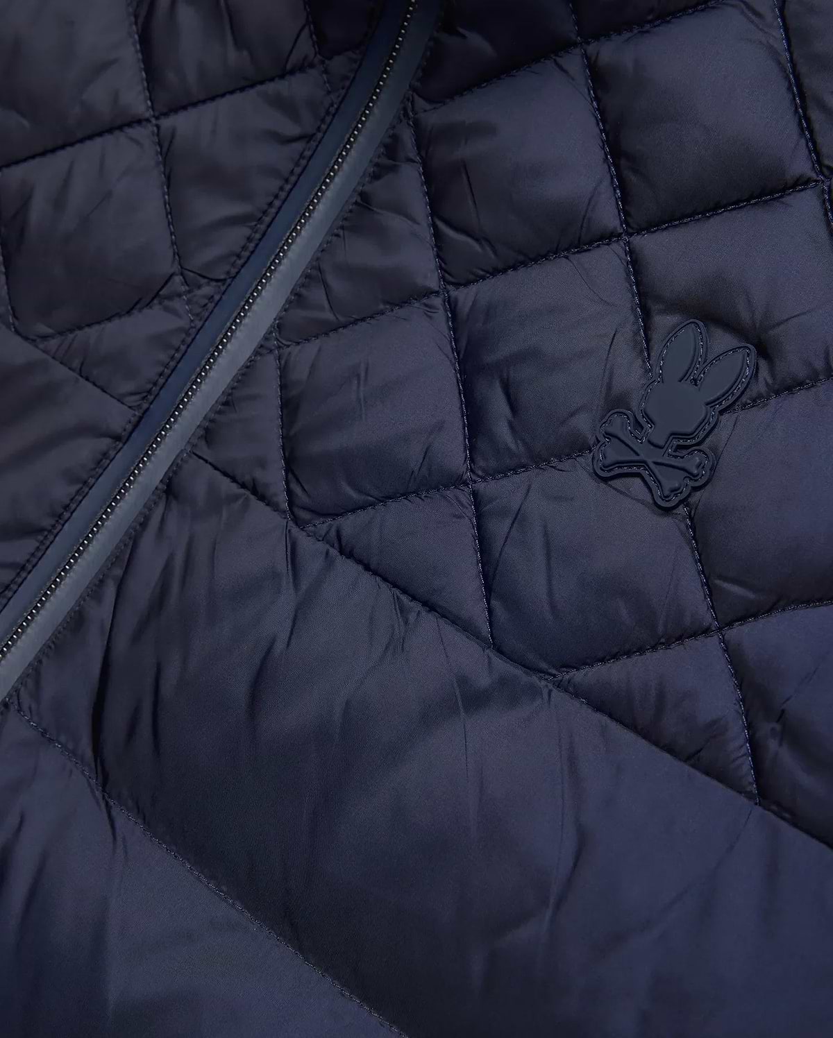 Mens Emerik Puffer Jacket, a navy quilted puffer jacket crafted from smooth nylon, featuring a dark zipper and a small, rubberized Psycho Bunny skull logo on the chest. (6)
