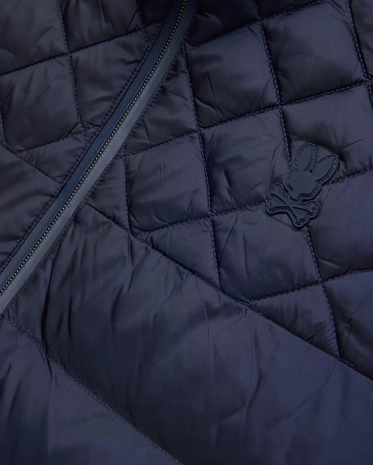 Mens Emerik Puffer Jacket, a navy quilted puffer jacket crafted from smooth nylon, featuring a dark zipper and a small, rubberized Psycho Bunny skull logo on the chest. (6)