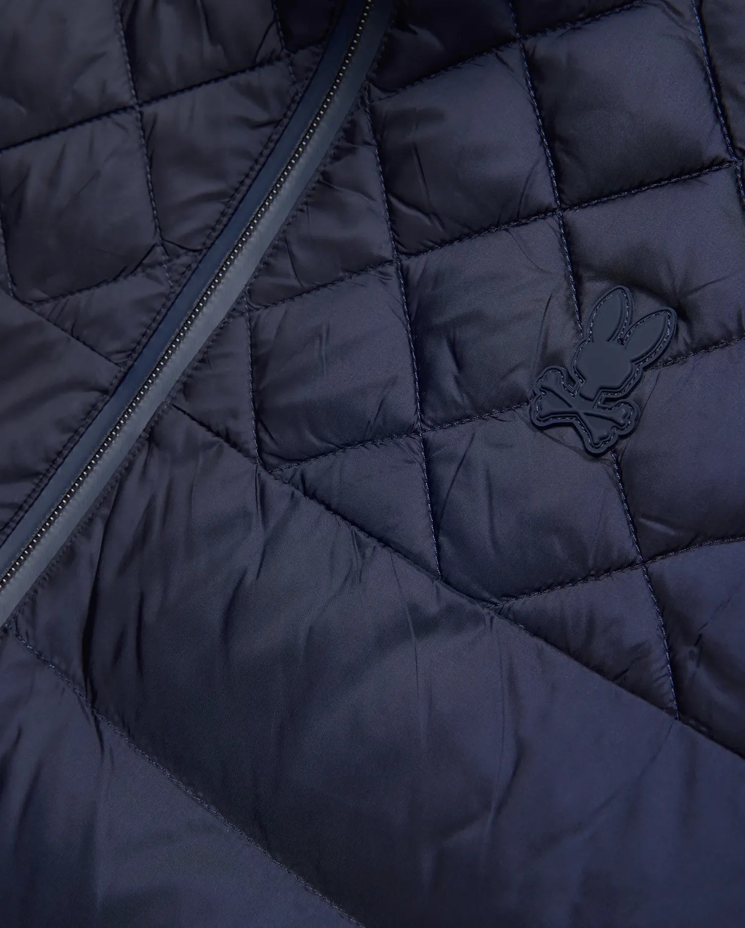 Mens Emerik Puffer Jacket, a navy quilted puffer jacket crafted from smooth nylon, featuring a dark zipper and a small, rubberized Psycho Bunny skull logo on the chest. (6)