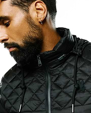 Black Mens Emerik Hooded Puffer Jacket with a quilted diamond pattern, featuring a small black rubberized Psycho Bunny skull logo on the left chest, silver-toned zipper pull and drawstring tips.