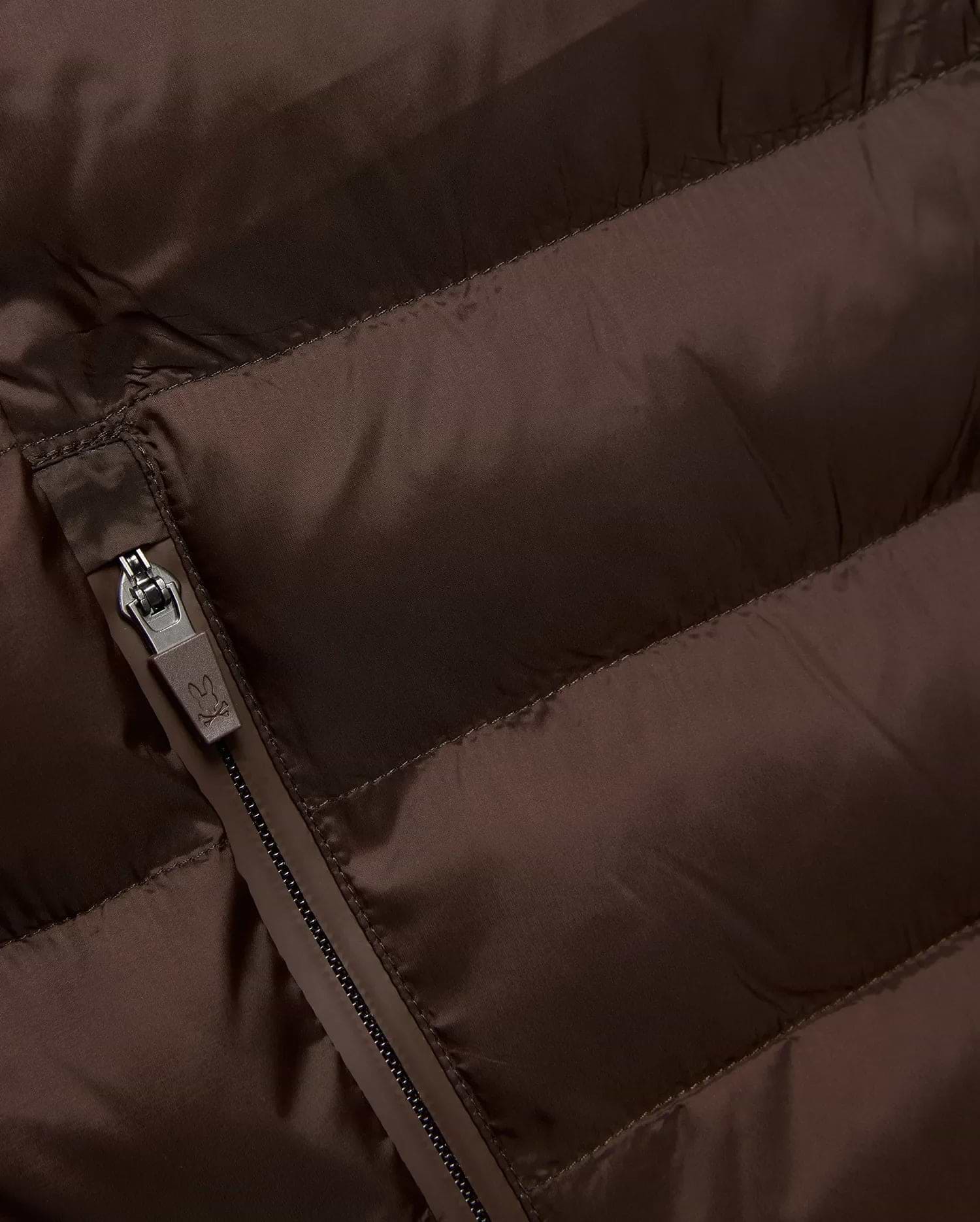 Mens Emerik Puffer Jacket in rich brown, crafted from smooth, quilted nylon. Features horizontal puffer channels and a dark grey zipper with a small Psycho Bunny skull logo pull. (6)