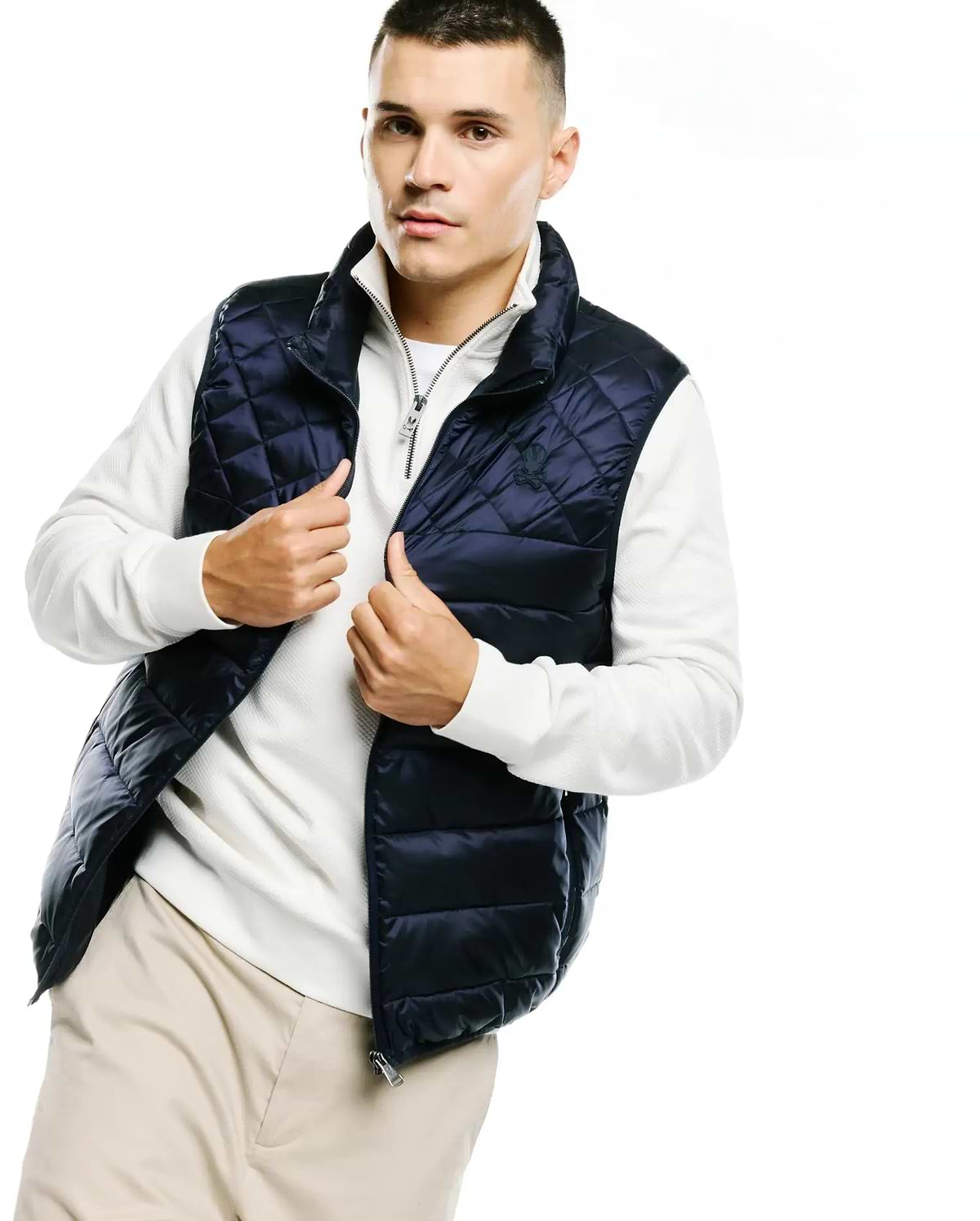 Mens Emerik Quilted Puffer Vest in navy blue, featuring diamond quilting, a full zip closure with a branded pull, and a small embroidered Psycho Bunny skull logo on the left chest. (4)