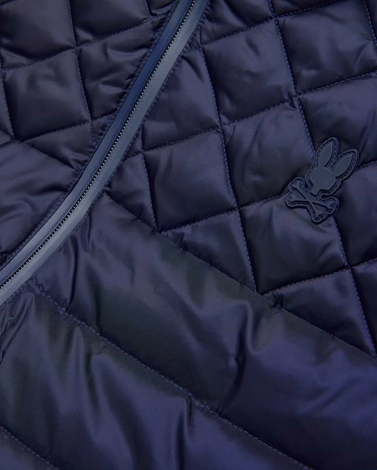 Mens Emerik Puffer Vest in navy, featuring a diamond quilted pattern, full-zip closure with dark trim, and a small, matching navy rubberized Psycho Bunny skull logo on the chest. (8)