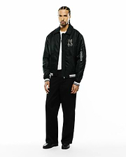 Mens Nathaniel Satin Coach Jacket in black, featuring a relaxed fit, large white embroidered Psycho Bunny skull logo on the left chest, white striped ribbed cuffs, and a Psycho Bunny branded tag on the sleeve. (4)