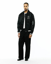 Mens Nathaniel Satin Coach Jacket in black, featuring a relaxed fit, large white embroidered Psycho Bunny skull logo on the left chest, white striped ribbed cuffs, and a Psycho Bunny branded tag on the sleeve. (4)