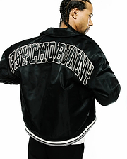 Black Mens Nathaniel Satin Coach Jacket, a relaxed fit, smooth satin jacket with a large white outlined PSYCHO BUNNY text logo across the upper back and a ribbed hem with white double stripes. (1)