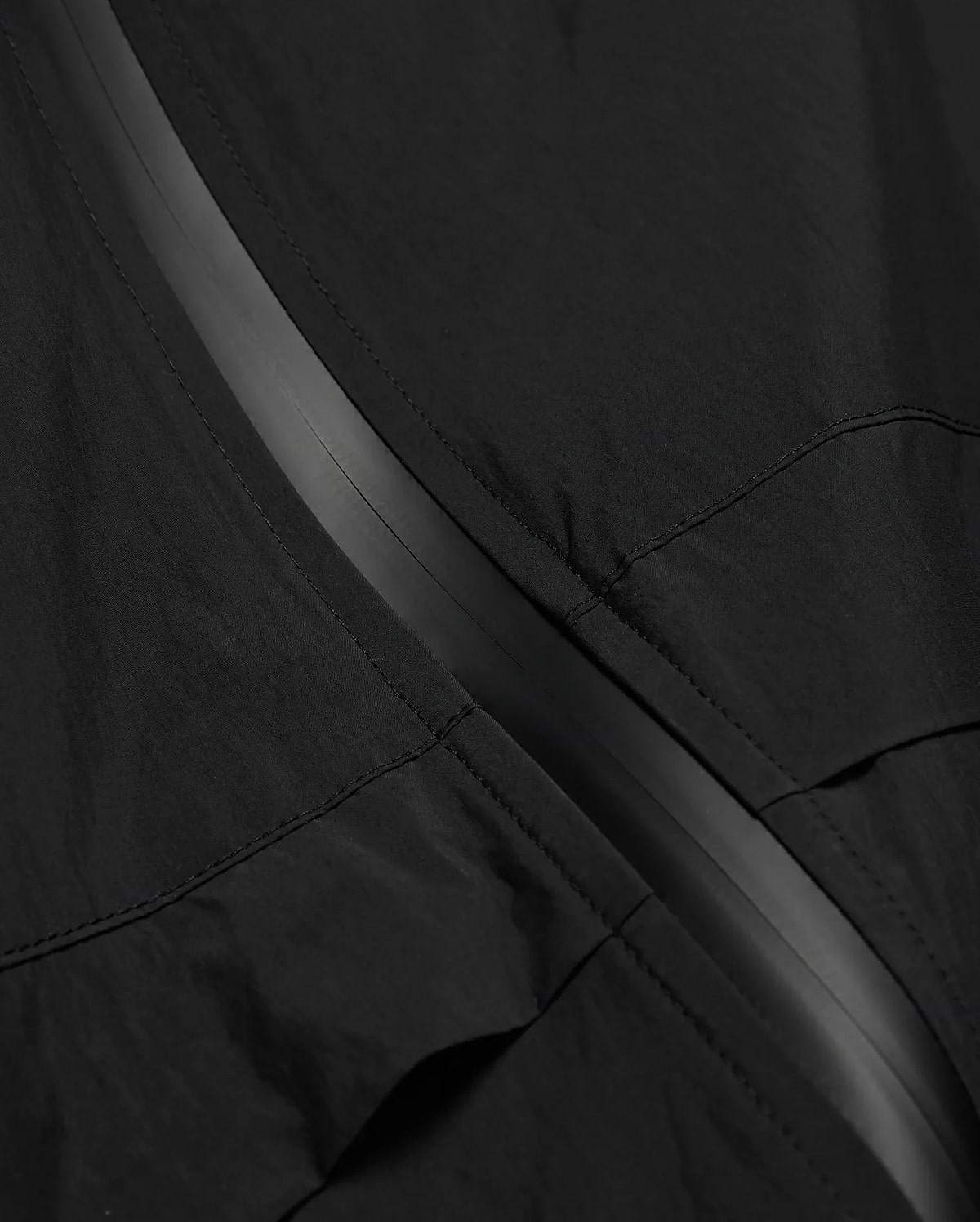 MENS JAVIER WINDBREAKER JACKET in black, featuring a subtle dark grey central zipper strip and visible panel stitching on lightweight, crinkled fabric. (6)