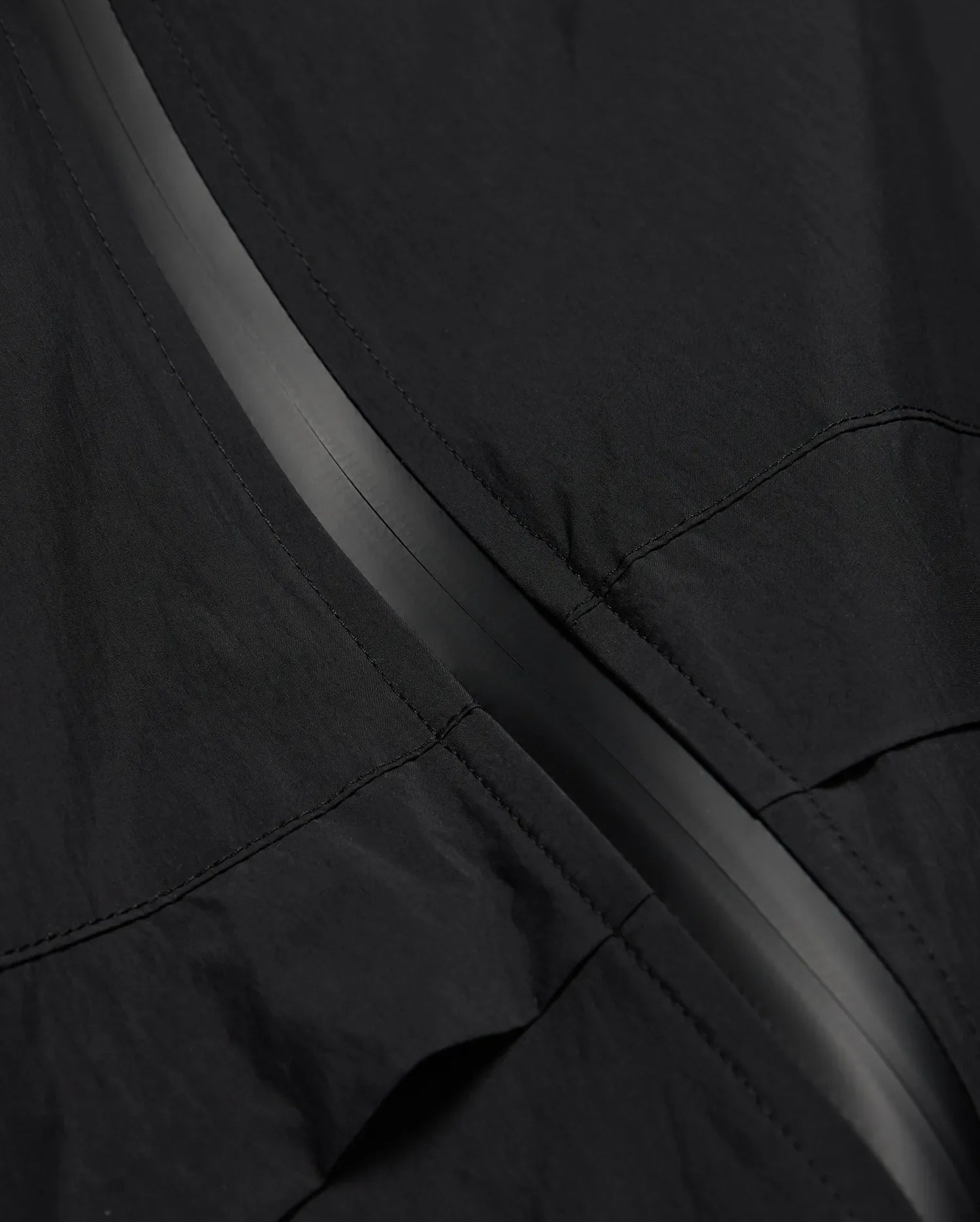 MENS JAVIER WINDBREAKER JACKET in black, featuring a subtle dark grey central zipper strip and visible panel stitching on lightweight, crinkled fabric. (6)