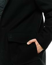 Black Mens Luther Wool Blend Coat with a classic fit, featuring a tonal embroidered Psycho Bunny skull logo on the flap pocket and a smooth wool blend texture.