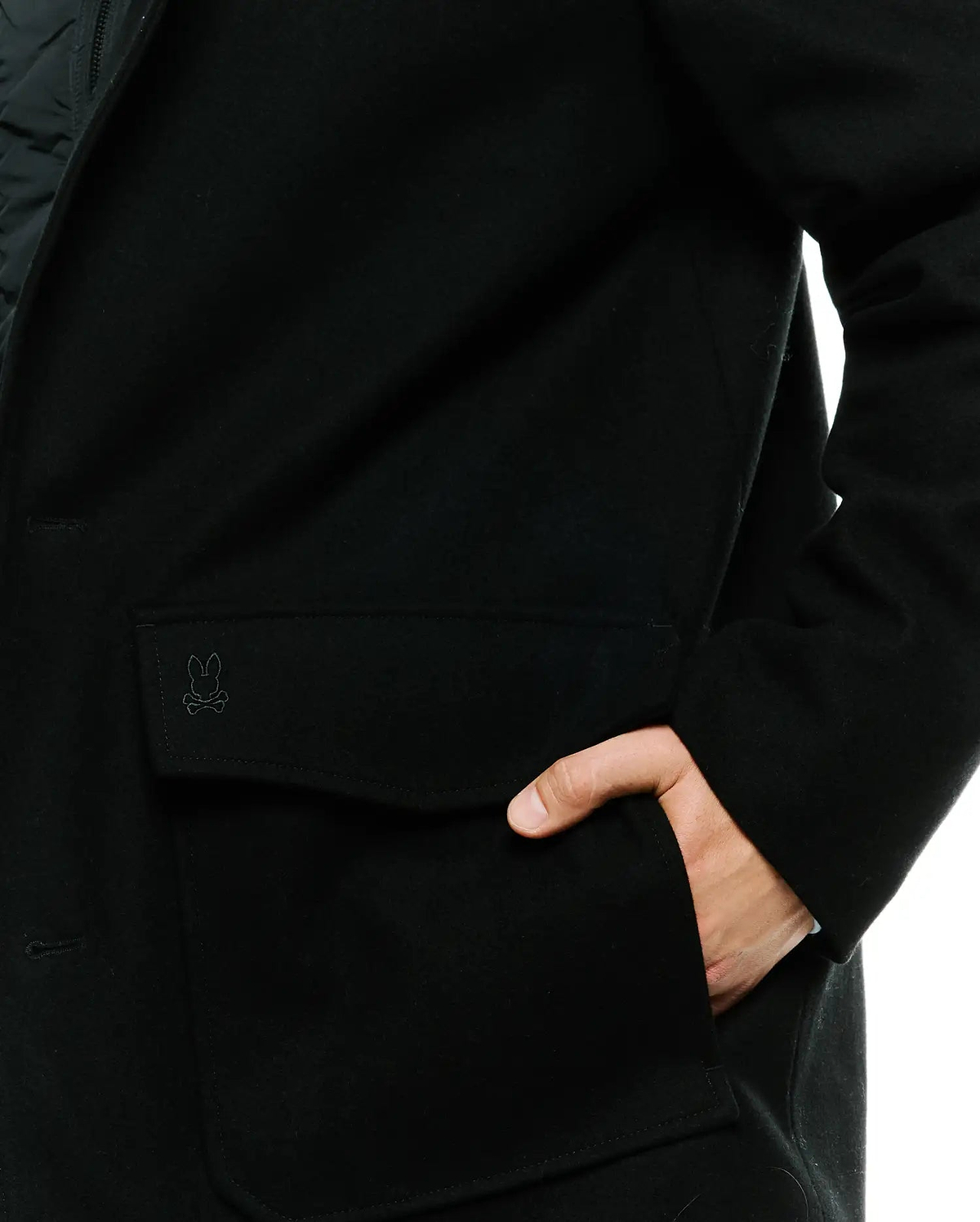 Black Mens Luther Wool Blend Coat with a classic fit, featuring a tonal embroidered Psycho Bunny skull logo on the flap pocket and a smooth wool blend texture.