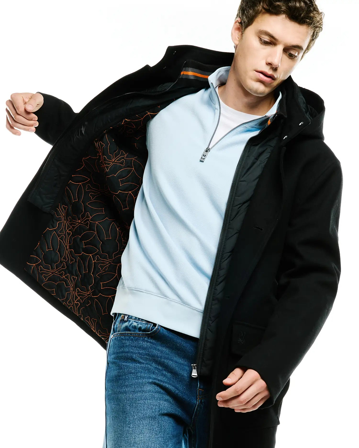 MENS LUTHER WOOL BLEND COAT, a black hooded classic fit coat with button closure, featuring a quilted black lining with an orange Psycho Bunny skull and crossbones pattern and a small embroidered logo on the sleeve.