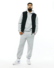 Mens Gordler Reversible Vest, black with navy interior, worn over a relaxed fit grey french terry hoodie and matching sweatpants featuring an embroidered Psycho Bunny logo.