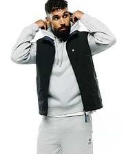 Mens Gordler Reversible Vest, a classic fit black vest with a smooth finish, featuring a navy interior, full zip, snap-button chest pockets, and a Psycho Bunny text label on the chest with a branded zipper pull.