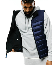 Mens Gordler Reversible Vest, a classic fit navy blue quilted puffer with full zip, reversing to matte black. Embroidered Psycho Bunny skull logo on left chest, smaller blue logo inside.