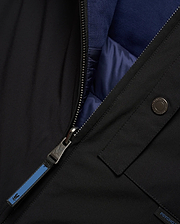 Mens Gordler Reversible Vest, black smooth woven outer, reversible to navy blue quilted interior with ribbed collar. Features a full zip with Psycho Bunny skull logo pull, branded snap, and Psycho Bunny text tag.