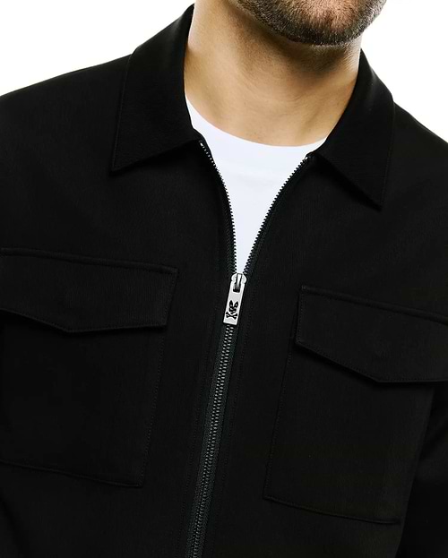 Men's Wayde Twill Overshirt in black, featuring a classic collar, full-zip front with a silver Psycho Bunny skull logo zipper pull, and two chest flap pockets, crafted from textured twill fabric for a relaxed fit. (2)