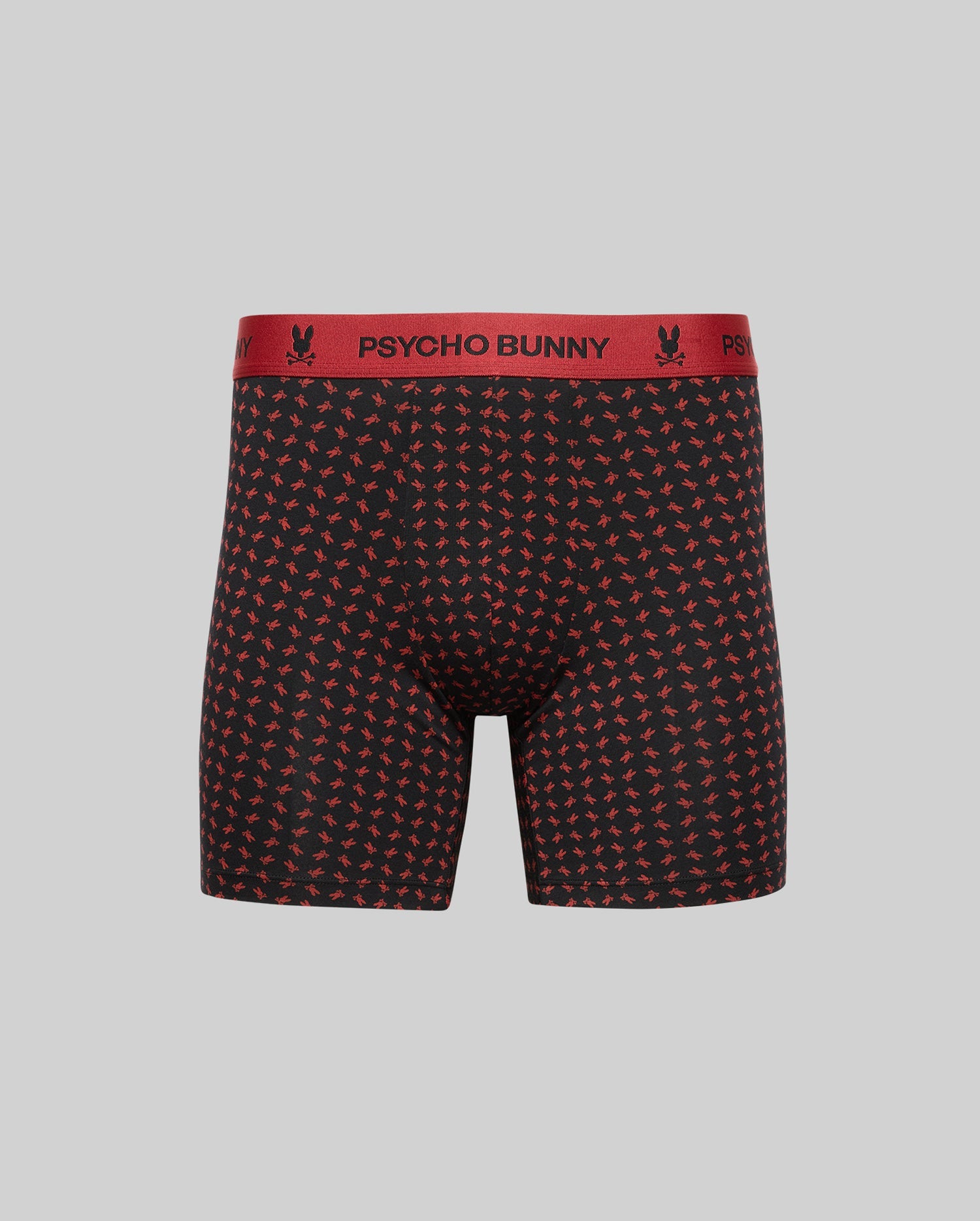 The Psycho Bunny MENS SINGLE BOXER BRIEF - MO1400010 features black Pima cotton with a red bunny and crossbones print, a red “PSYCHO BUNNY” waistband, and is designed for all-day comfort on a plain grey background. (1)