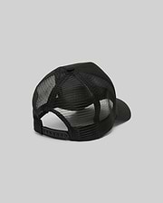 The Psycho Bunny MENS RYDER TRUCKER CAP (MO1500030) in black mesh and cotton twill is shown from the back, featuring an adjustable snapback closure and curved brim against a plain gray background.
