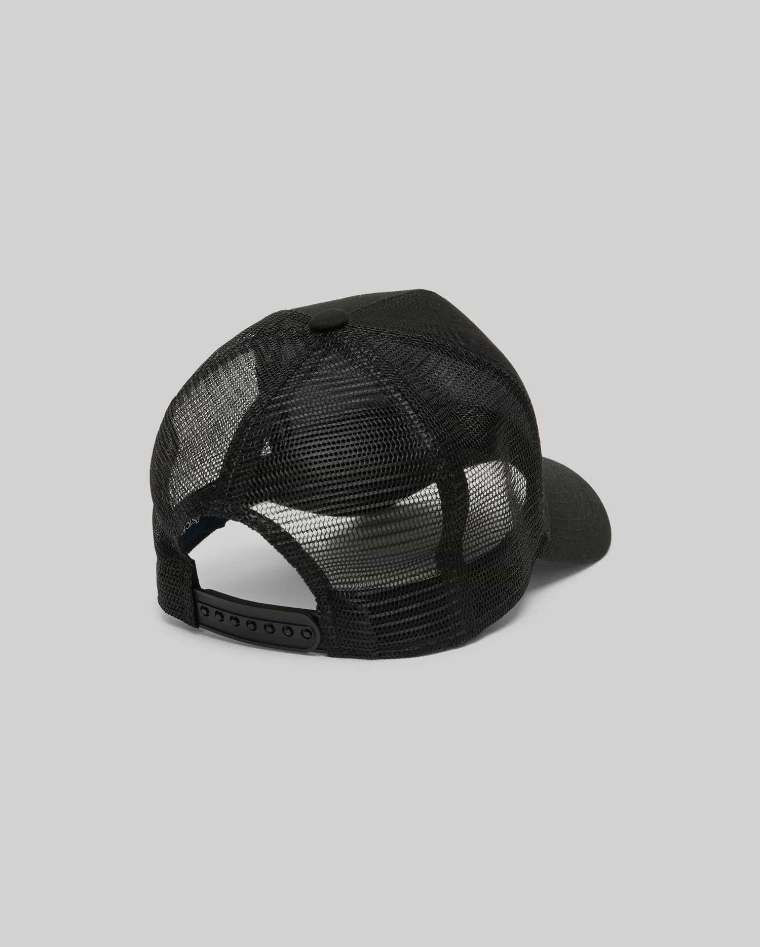 The Psycho Bunny MENS RYDER TRUCKER CAP (MO1500030) in black mesh and cotton twill is shown from the back, featuring an adjustable snapback closure and curved brim against a plain gray background.