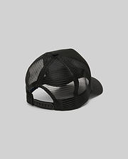 The Psycho Bunny MENS RYDER TRUCKER CAP (MO1500030) in black mesh and cotton twill is shown from the back, featuring an adjustable snapback closure and curved brim against a plain gray background.