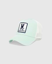 MENS ADAMO TRUCKER CAP in mint green cotton twill with white mesh back, featuring a large front embroidered patch with the navy blue Psycho Bunny skull logo and text on a white background.