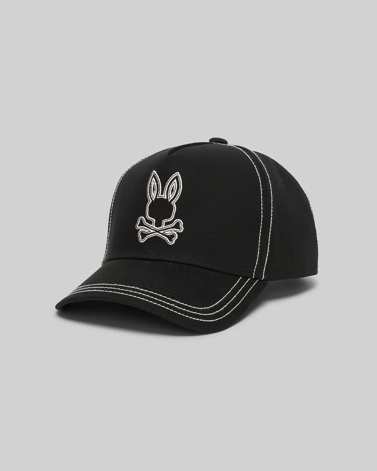 Mens Oscar Trucker Cap in black structured cotton twill, featuring a prominent white embroidered Psycho Bunny skull logo on the front and contrasting white stitching details throughout. (2)