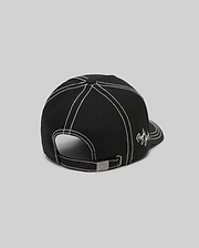 Mens Oscar Trucker Cap in black, featuring prominent white contrast stitching across panels and brim, an embroidered white Psycho Bunny script logo on the side, and a metal buckle with an engraved bunny skull. (4)