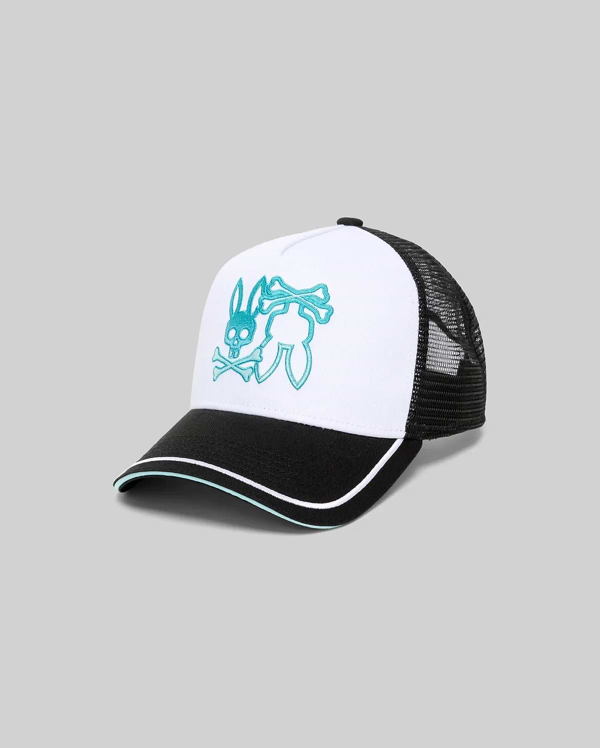 Mens Aram Trucker Cap with a white cotton twill front panel, black mesh back, and black brim featuring white and teal piping. A large, central teal embroidered Psycho Bunny skull logo with crossbones adorns the front.