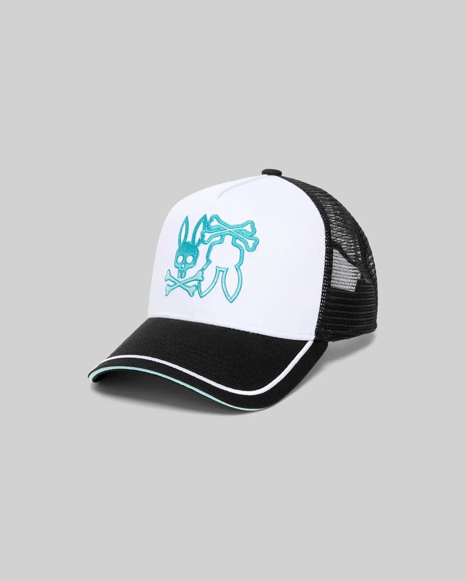 Mens Aram Trucker Cap with a white cotton twill front panel, black mesh back, and black brim featuring white and teal piping. A large, central teal embroidered Psycho Bunny skull logo with crossbones adorns the front.