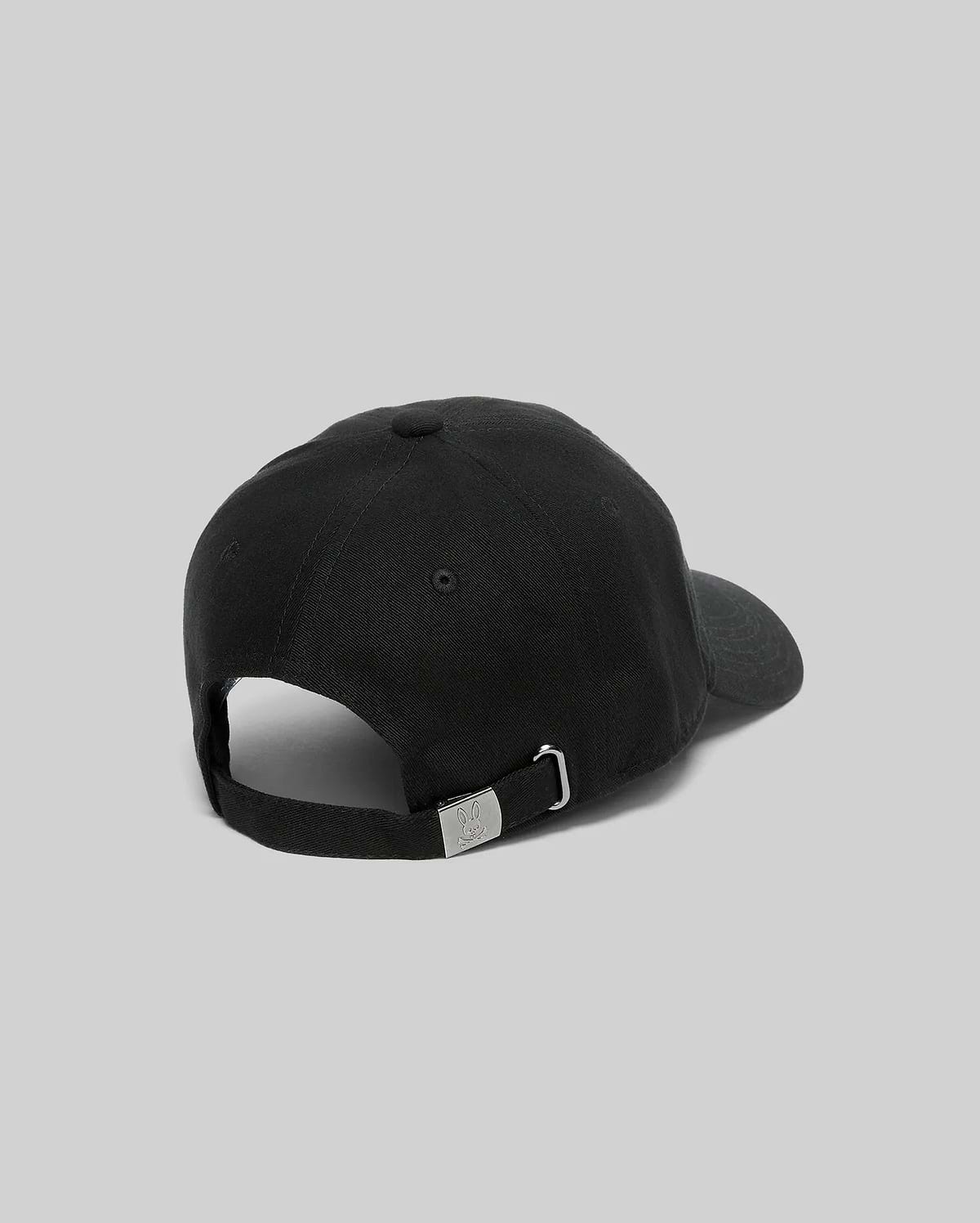 Black Mens Jimmy Baseball Cap with a smooth twill texture, featuring an adjustable strap and a small metallic Psycho Bunny skull logo on the silver buckle at the back.