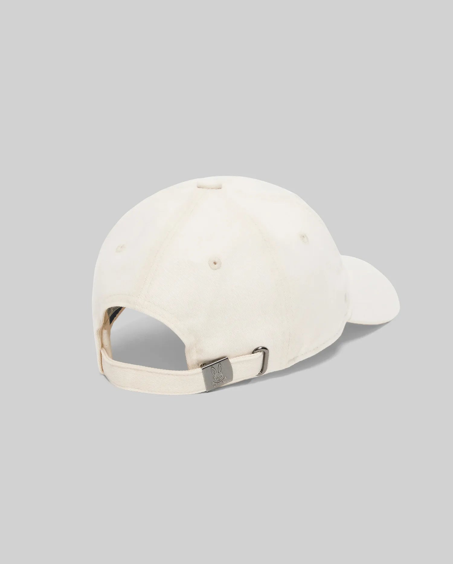 Mens Jimmy Baseball Cap in cream cotton twill, featuring an adjustable strap with a gunmetal buckle embossed with the iconic Psycho Bunny skull logo.