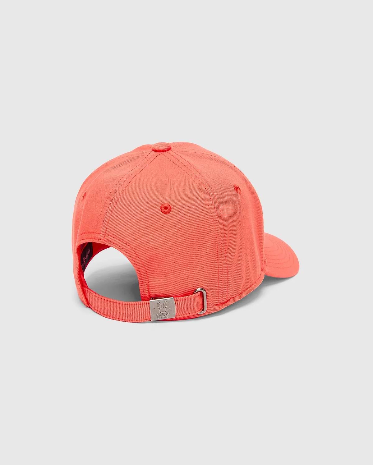 Mens Craig Baseball Cap in vibrant coral twill, featuring an adjustable strap with a silver-tone metal buckle engraved with the iconic Psycho Bunny skull logo.