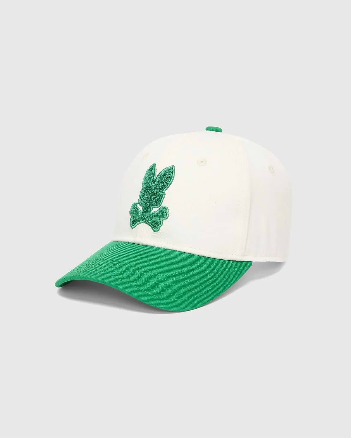 Mens Craig Baseball Cap in cream cotton twill with a vibrant green brim and matching top button, featuring a prominent, textured green embroidered Psycho Bunny skull logo on the front.