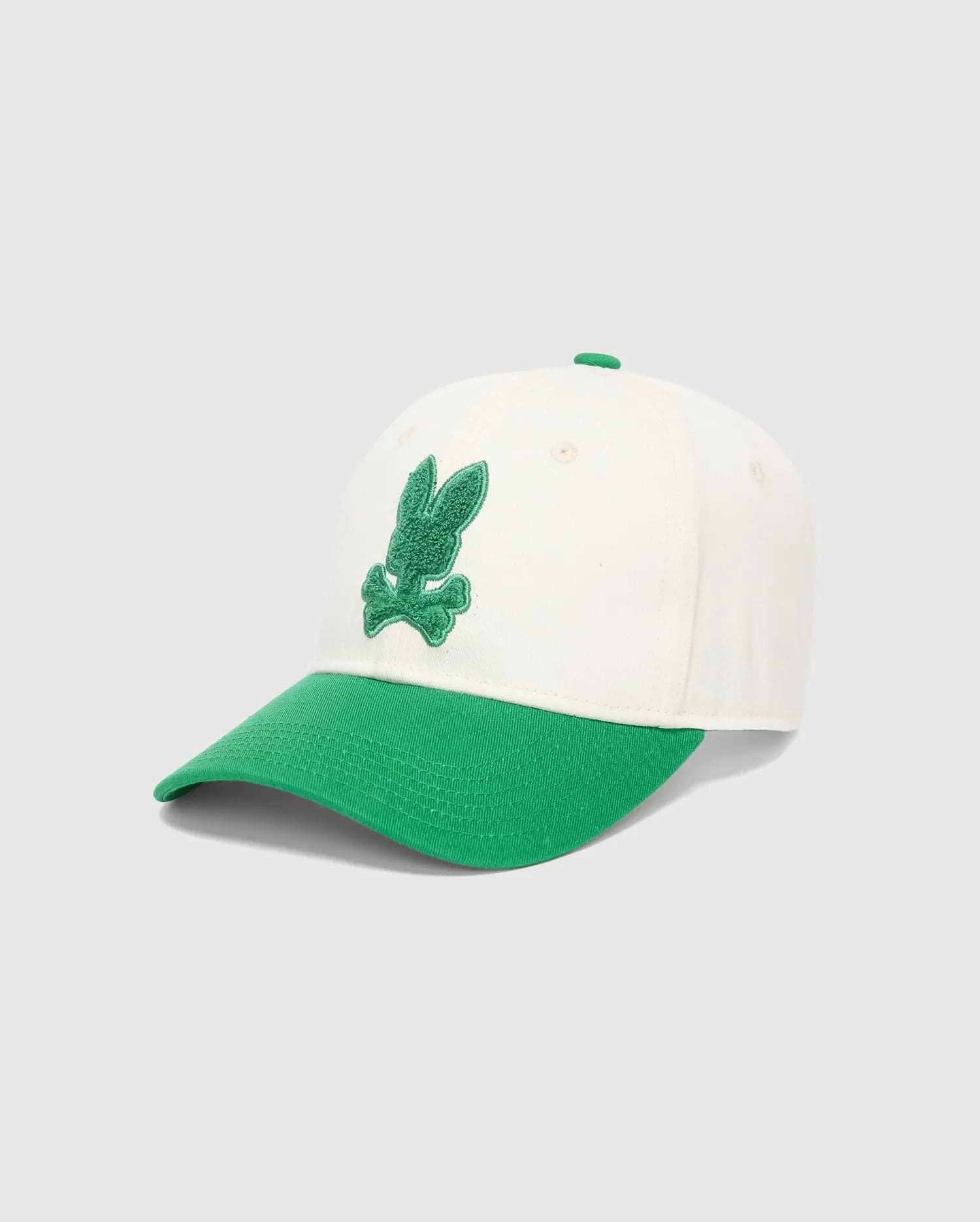Mens Craig Baseball Cap in cream cotton twill with a vibrant green brim and matching top button, featuring a prominent, textured green embroidered Psycho Bunny skull logo on the front.